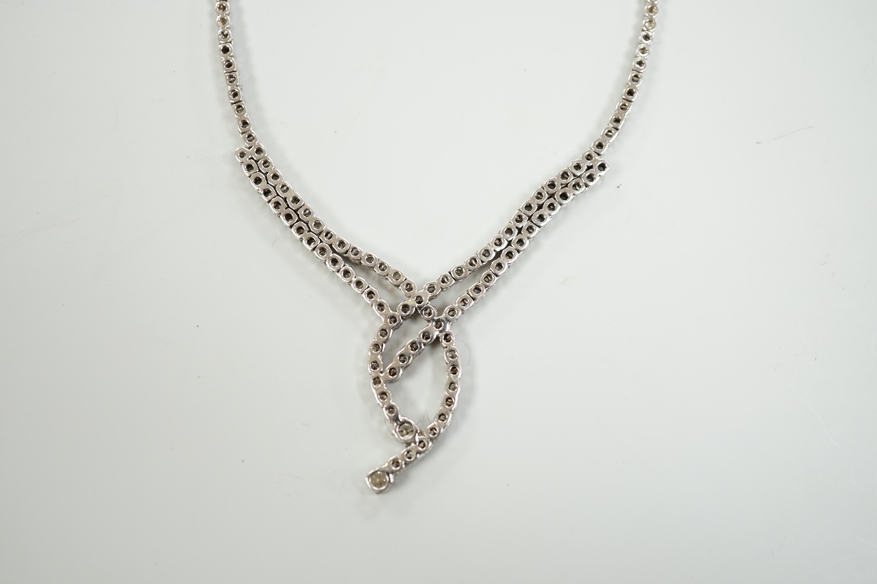 A modern 750 white metal and diamond set interwoven necklace, approx. 44cm, gross weight 28.1 grams.